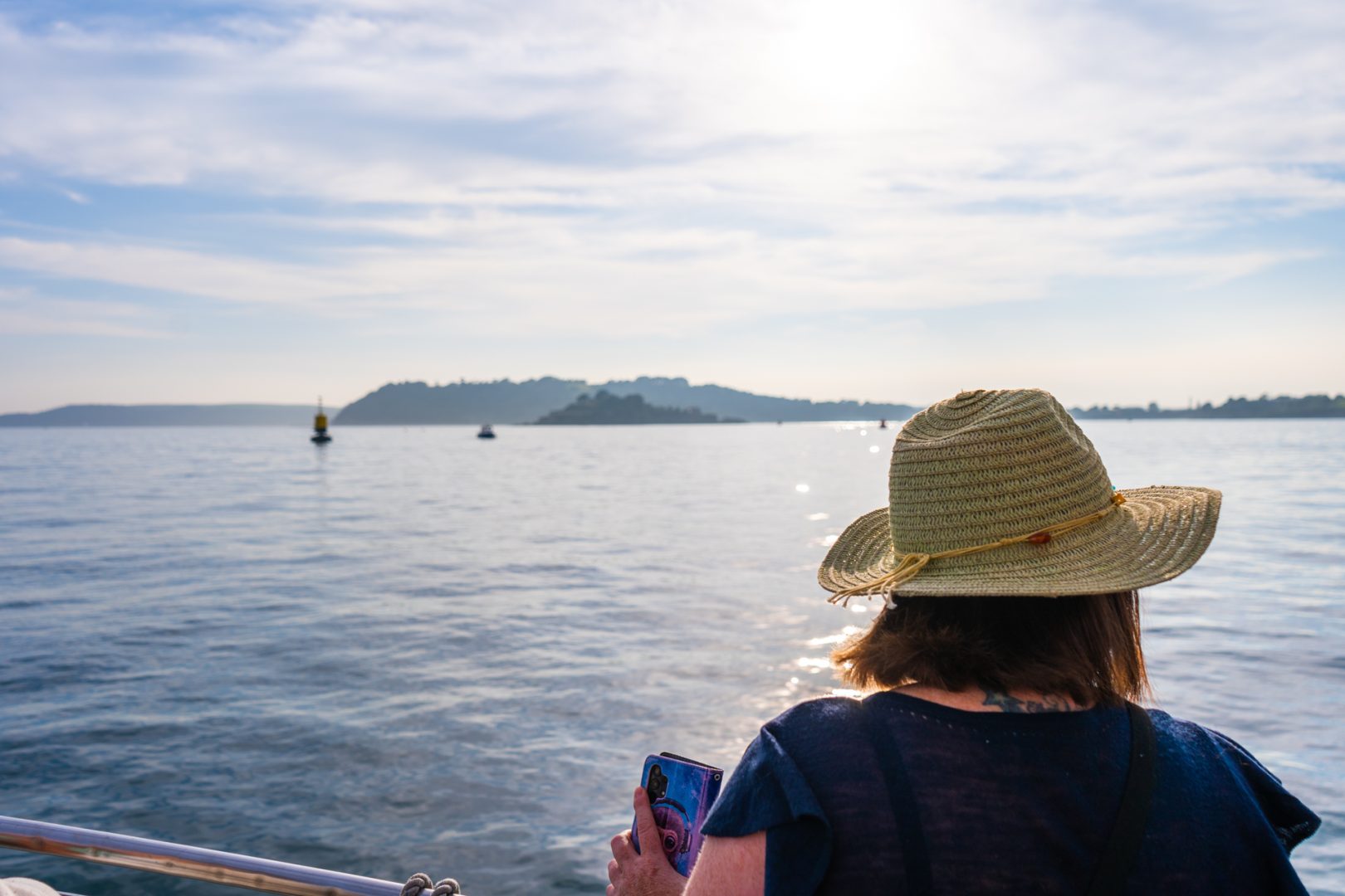 Woman with hat overlooking Plymouth Sound from boat